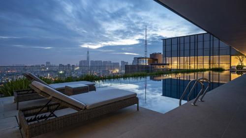 a rooftop patio with a view of a city at The MARQ Elite Apartel District 1 HCMC by SSens in Ho Chi Minh City