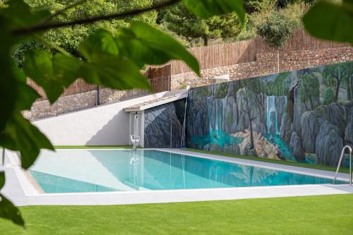 uma piscina com um mural numa parede em Apartamentos 7 puentes sierra Cazorla em Burunchel