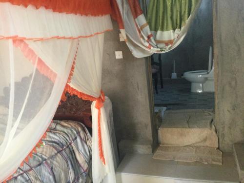 a bedroom with a bed and a bathroom with a toilet at St.Francis Retreat Center in Naro Moru