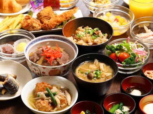 una mesa cubierta con cuencos de diferentes tipos de alimentos en Dormy Inn Chiba City Soga, en Chiba