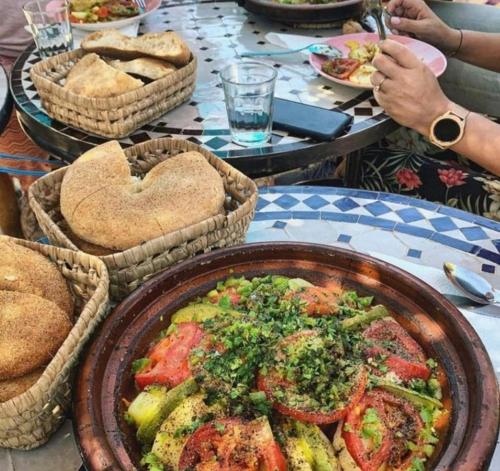 stół z koszami chleba i talerzem jedzenia w obiekcie Hostel World Rooftop Marrakech w Marakeszu