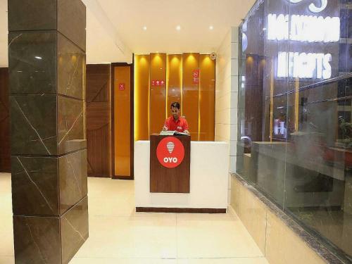 a man standing behind a podium in a lobby at Hotel O Grand Star in Amritsar