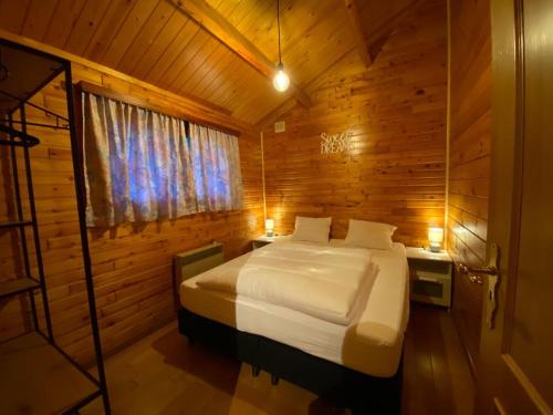 una camera con un letto in una cabina di legno di Chalet 't Musje a Durbuy