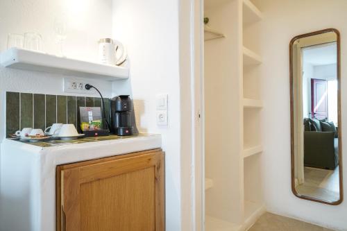 una piccola cucina con lavandino e specchio di 23 Hotel Mykonos a Mykonos Città