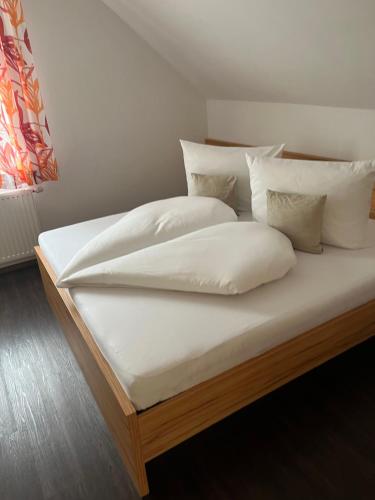 a bed with white sheets and pillows on it at Apartment Schlickenhof in Hintergöriach