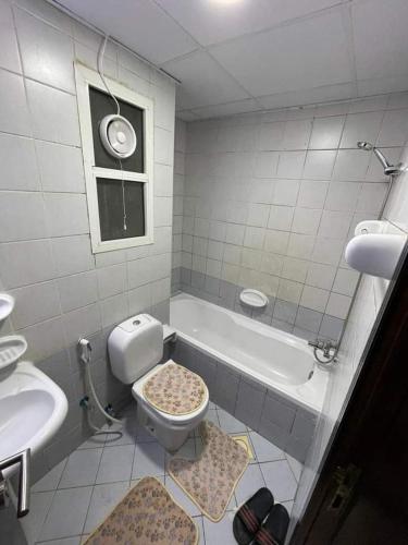 a bathroom with a toilet and a sink and a tub at شقه فندقيه in Dubai