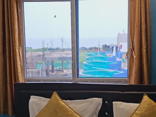 una ventana de hotel con vistas a la piscina en Hotel Sea Rock, en Puri