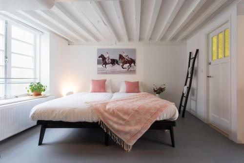 Schlafzimmer mit einem Bett mit rosa und weißer Bettwäsche in der Unterkunft Hotel Zilt Studio's in Vlissingen