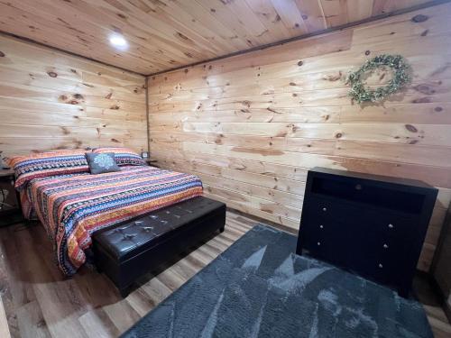 a bedroom with a bed in a wooden wall at Riverview Escape - Cabins on the Ohio River 
