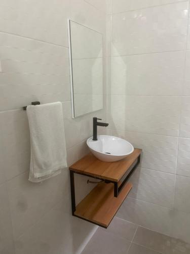 a white bathroom with a sink and a mirror at Pousada As Ondas in Guarujá