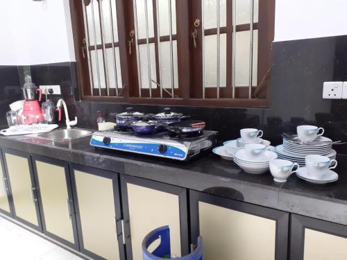 a kitchen counter with a stove and dishes on it at VILLA GREEN VILLAGE in Kamburugamuwa