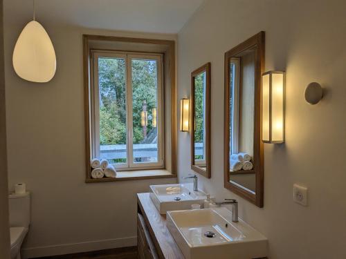 a bathroom with two sinks and two mirrors at Villa Eliane - parking privé in Étretat