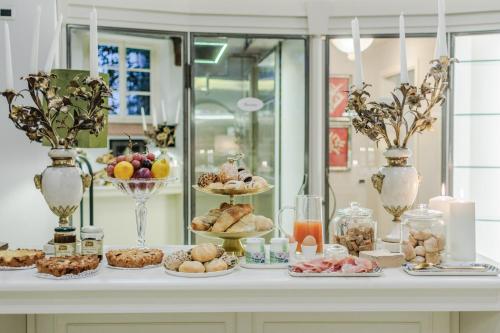 une table remplie de différents types de pâtisseries et de desserts dans l'établissement Lucca Heritage Retreat, à Lucques