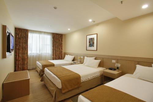 Habitación de hotel con 3 camas y TV en Windsor Florida Hotel en Río de Janeiro