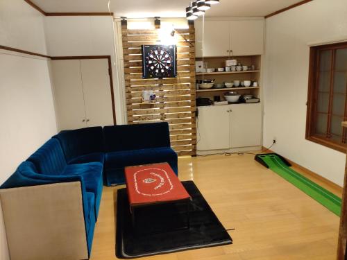 a living room with a blue couch and a table at NOBORIBETSU no MORI in Noboribetsu