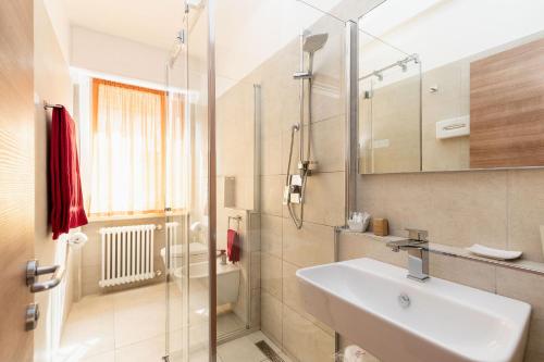 a bathroom with a sink and a glass shower at Hotel Garni Ischia in Malcesine