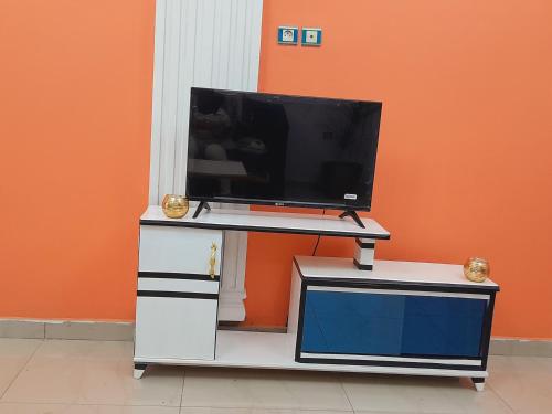 un televisor en la parte superior de un tocador con un televisor en él en OLD Bonapriso Paisible Appart meublé 2 Chambres en Duala