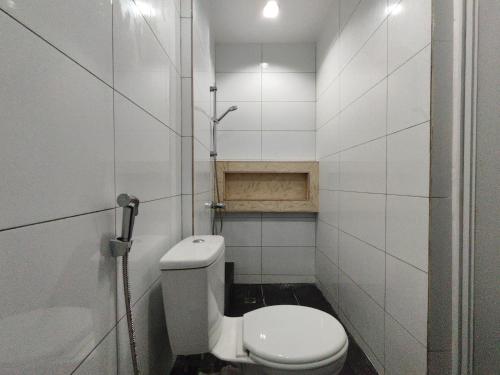 a white bathroom with a toilet and a sink at Sibu Q2 Homestay -1st Floor, 4 Rooms 5 Beds in Sibu