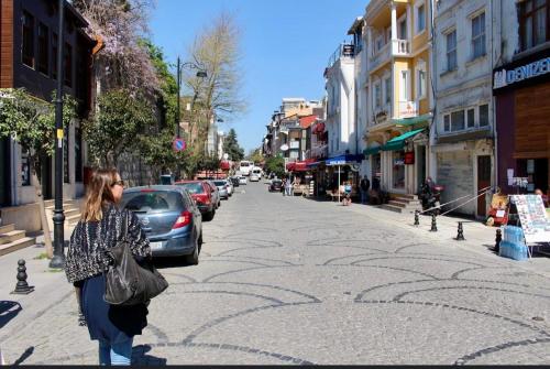 a woman walking down a street with a maze on the sidewalk at Hera Sultanahmet in Istanbul