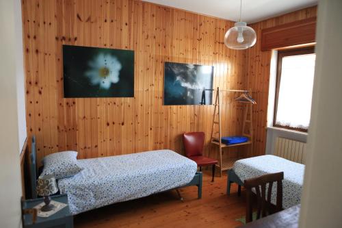 um quarto com 2 camas, uma cadeira e uma janela em B&B All'Antica Fonte em Forgaria nel Friuli