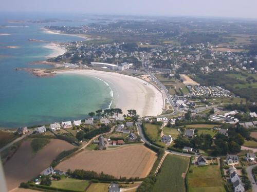 una vista aérea de la playa y del océano en Résidence Les Trois Mâts à Trestel, en bord de mer, sur la Côte de Granit Rose en Trévou-Tréguignec