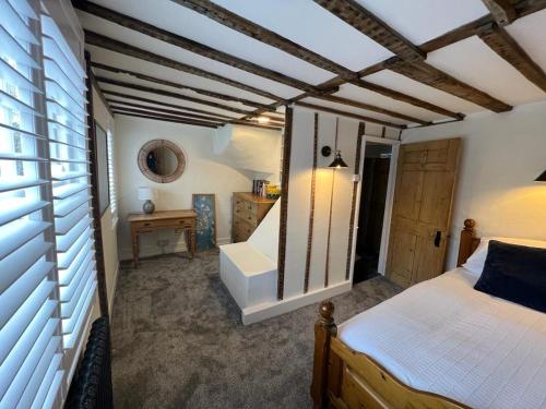 a bedroom with a bed and a wooden ceiling at The Cottage, 13 Golden Sq. in Kent