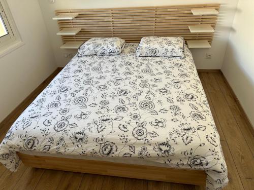 Schlafzimmer mit einem Bett mit einer schwarzen und weißen Bettdecke in der Unterkunft Appartement vue mer , plage à 50m in Six-Fours-les-Plages