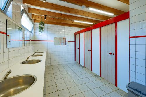 een badkamer met 2 wastafels en 2 spiegels bij Woodlodge High Chaparral in Oorsbeek