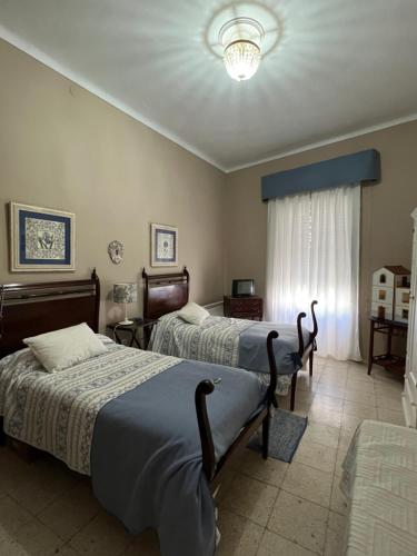 a bedroom with two beds and a chandelier at Vivienda La Puerta del Perdon in Constantina