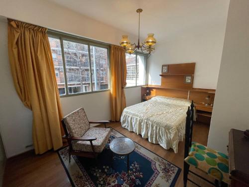 布宜諾斯艾利斯的住宿－Expansive Villa Urquiza Retreat A Versatile Haven for Six，卧室配有床、椅子和窗户。
