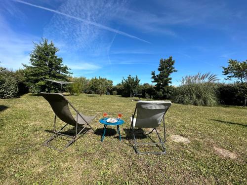 two chairs and a table in the grass at Maison Familiale Proche Plage, Marché & Commerces - 6 pers. Classée 3 étoiles in La Brée-les-Bains