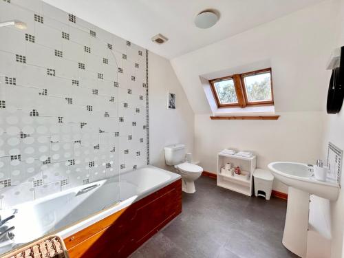 a bathroom with a tub and a toilet and a sink at Homestead House, Fort Augustus in Fort Augustus