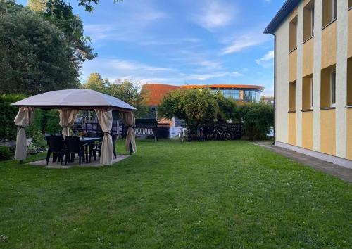 un tavolo e sedie sotto un ombrellone in un cortile di Cosy studio apartment with the garden a Druskininkai