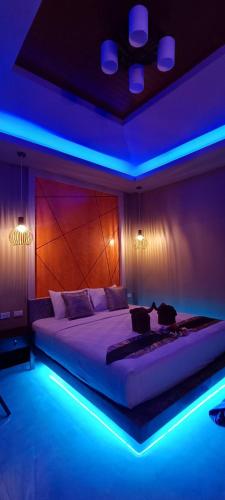a bedroom with a large bed with blue lights at Fill - Feel @ Long Beach Resort in Ko Lanta