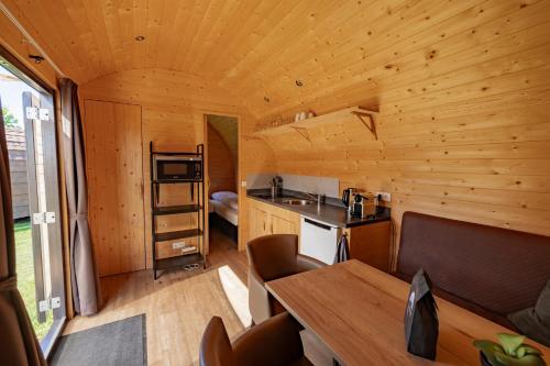 a kitchen and dining room of a log cabin at Family Woodlodge High Chaparral in Oorsbeek
