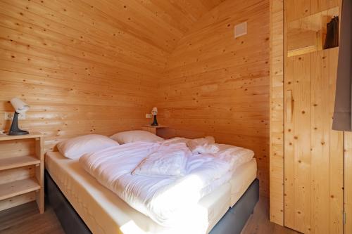1 dormitorio con 1 cama en una habitación de madera en Family Woodlodge High Chaparral, en Oorsbeek