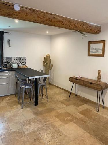 - une cuisine avec une table et un banc dans une pièce dans l'établissement Maison Marceau Gruissan, à Gruissan