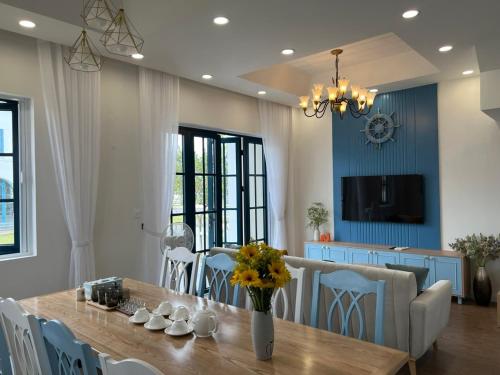 a dining room with a wooden table and chairs at KB Villas 58 in Bình Sum