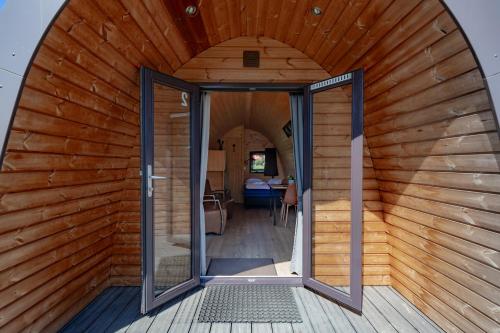 an open door of a small house with a wooden wall at Woodlodge High Chaparral in Oorsbeek