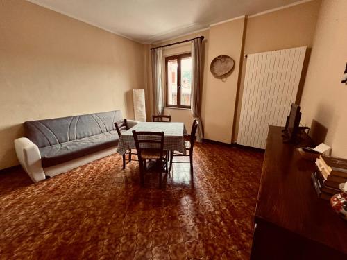 ein Wohnzimmer mit einem Sofa, einem Tisch und Stühlen in der Unterkunft Il vecchio granaio in Ruino