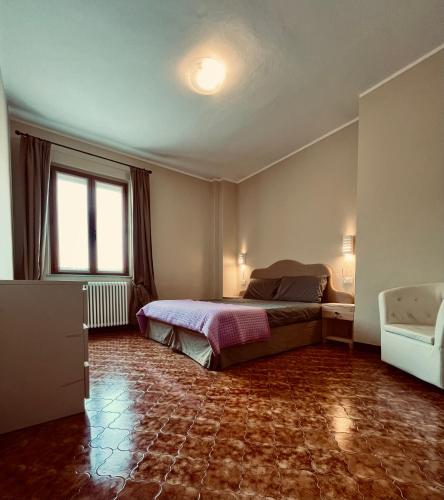 Schlafzimmer mit einem Bett und einem Fenster in der Unterkunft Il vecchio granaio in Ruino