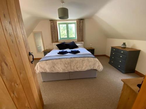a bedroom with a large bed and a window at Mallards Barn on a rural farm in Dingestow