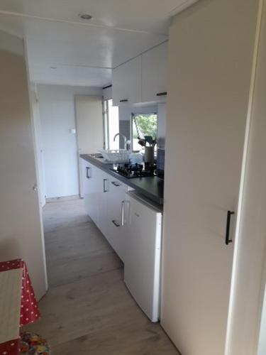 une cuisine avec des armoires blanches et un comptoir noir dans l'établissement Bellevues Glamping and Camping, à Mérignac