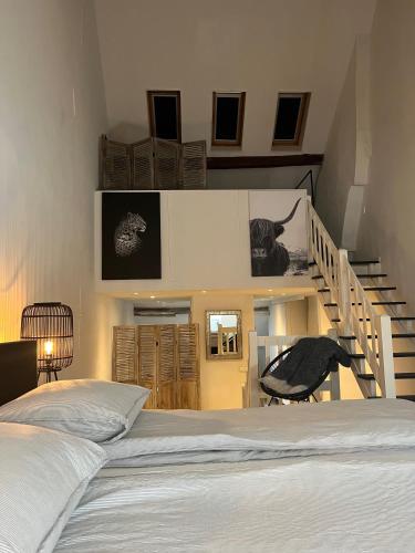 a bedroom with a bed and a staircase at Monumentale stadswoning in hartje binnenstad in Maastricht