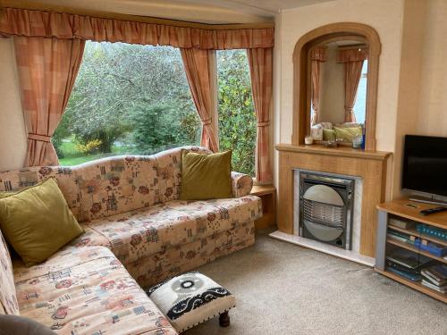 a living room with a couch and a fireplace at Clashmore Wood in Dornoch