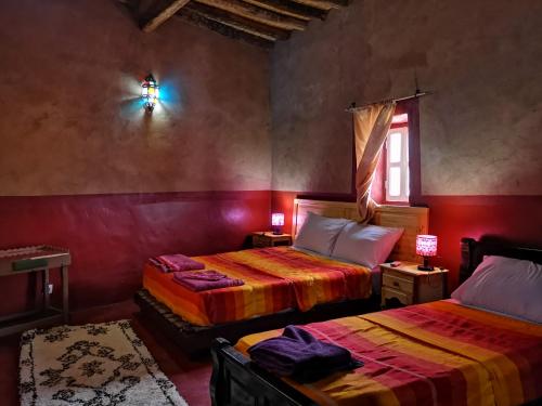 ein Schlafzimmer mit zwei Betten und einem Fenster in der Unterkunft Riad Dar Zaouia in Zagora