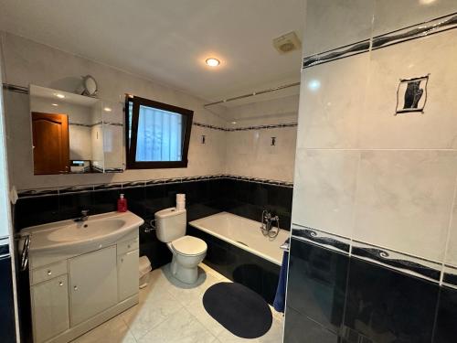 a bathroom with a toilet and a tub and a sink at Casa Moya Moraira - Seaview Villa in Teulada