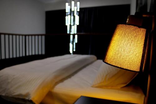 ein Schlafzimmer mit einem Bett mit einer Lampe daneben in der Unterkunft issi in Tbilisi City
