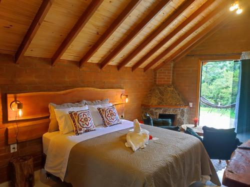 een slaapkamer met een bed met een knuffeldier erop bij Pousada das Castanheiras in Monte Verde