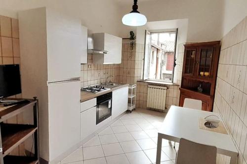 una cocina con electrodomésticos blancos y una mesa. en *Piazza Italia* Vicino Autostrada*Roma 40 min.*, en Orte